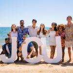 james cook university students on beach with JCU sign