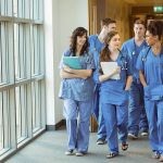 medical students wearing scrubs walking in hospital