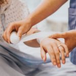 nurse wrapping patient's arm with bandage