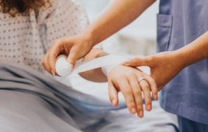 nurse wrapping patient's arm with bandage