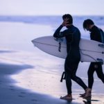 surfers walking on the beach