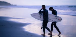 surfers walking on beach