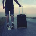 guy with luggage on road