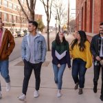 university students walking on sidewalk