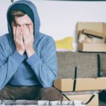 stressed man covering face with hands