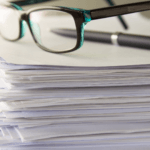 stack of paperwork with glasses