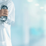 doctor in lab coat holding stethoscope