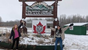 Emily and Supreet in front of Ile a la Crosse sign