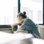 homesick university student looking out window