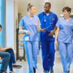 Medical students wearing scrubs walking in hospital hallway